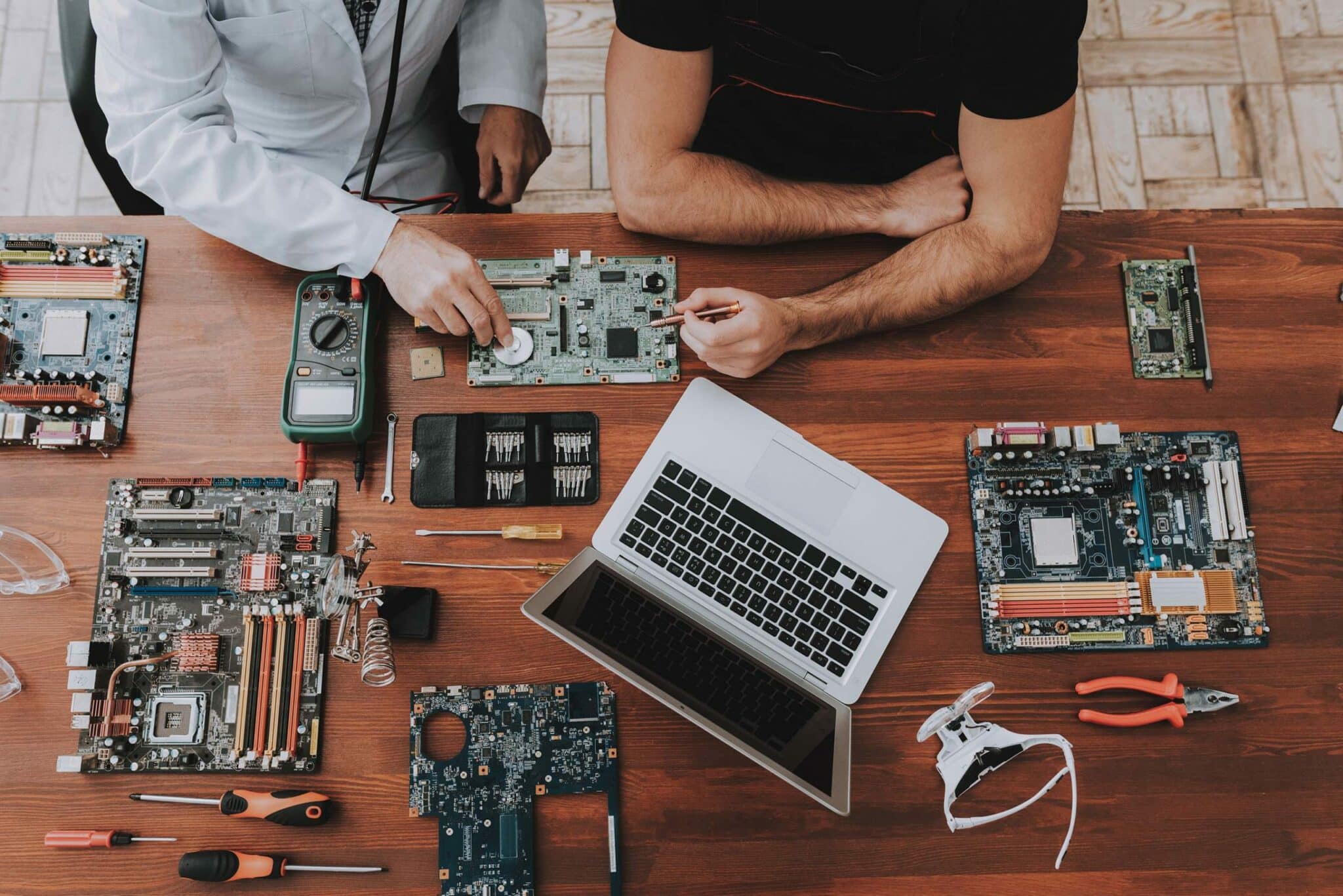 Two men with motherboards and tools